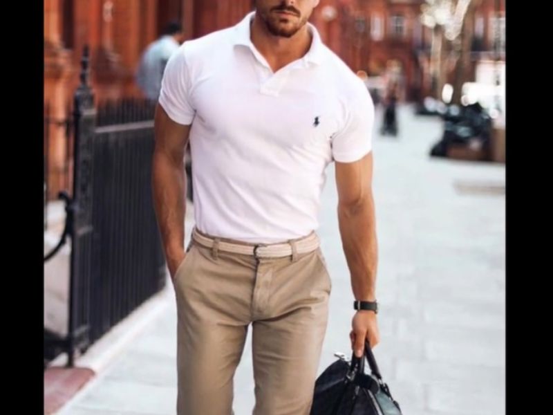 Man in khaki trousers and white polo holding a bag