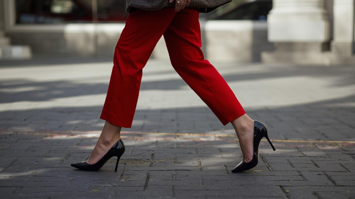 Black heels paired with red pants, showing what shoes to wear with red pants for women.