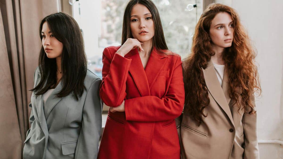 Three women wearing stylish blazers paired with jeans, showcasing different colors and fits, illustrating the best women’s blazers to wear with jeans.
