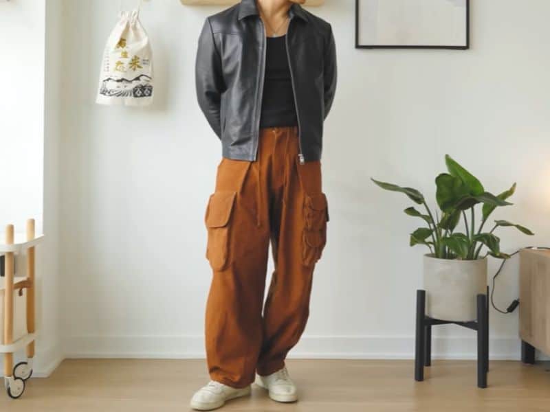 Man wearing stylish brown cargo pants with a casual jacket, standing indoors – modern men’s fashion outfit inspiration.