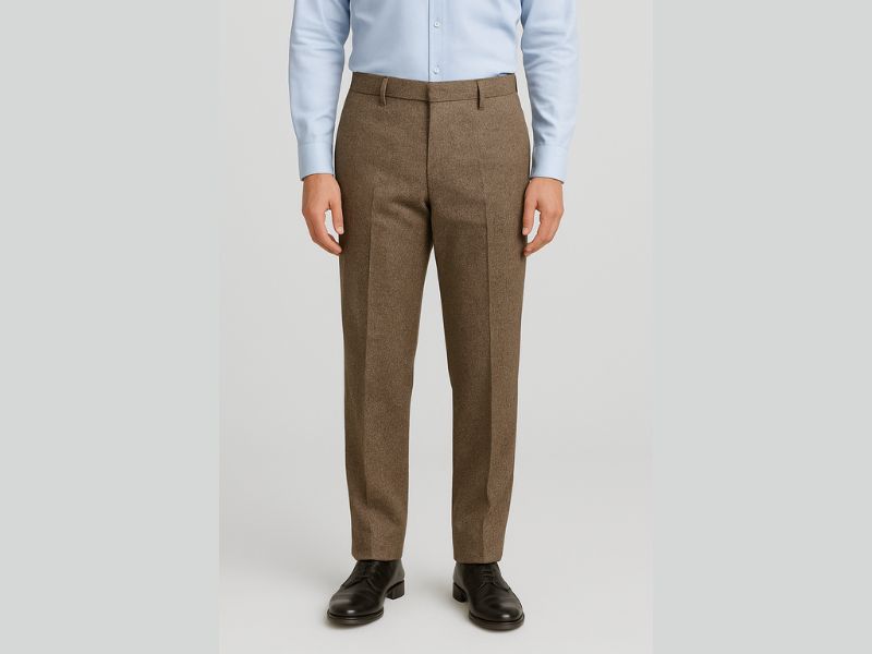 Man wearing tailored tweed trousers in a high-quality natural setting, styled for a polished and classic look.